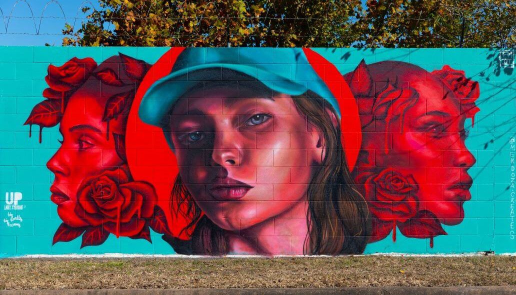 Mural of three women along the outer wall of the Kashmere bus operating facility at 5700 Eastex Freeway in Houston
